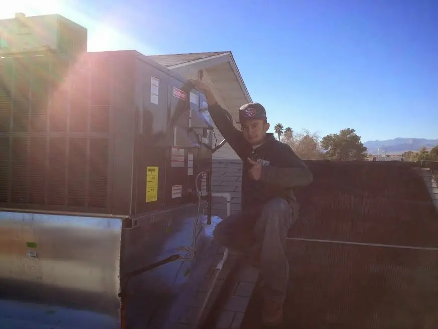 HVAC technician performing AC Tune-Up on a rooftop unit in Pulaski